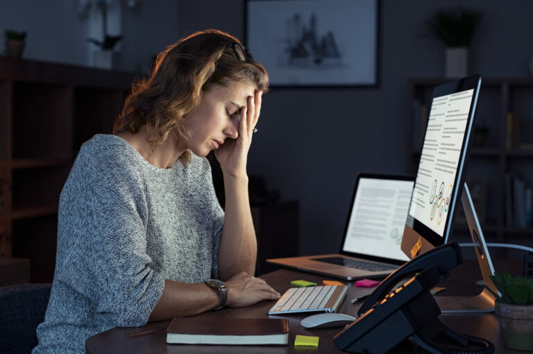 Woman experiencing stress and burnout while working on a computer