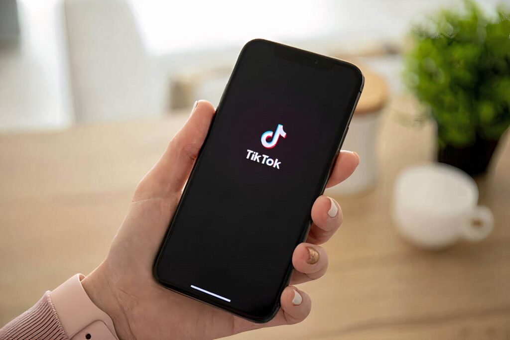 An apartment resident holding a cell phone with TikTok on it.