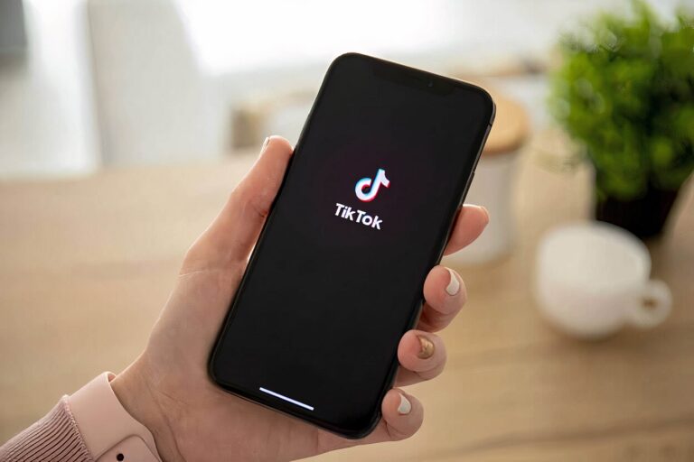 An apartment resident holding a cell phone with TikTok on it.