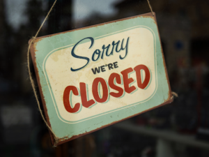 Closeup of a Sorry We’re Closed Sign in a store window