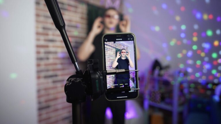 A TikTok creator stands in front of a phone on a tripod.