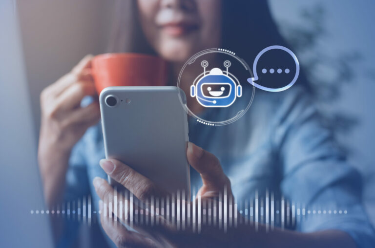 Person holds a coffee cup while chatting with a chatbot on their cell phone