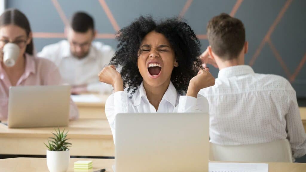 Ecstatic businesswoman celebrating at her laptop