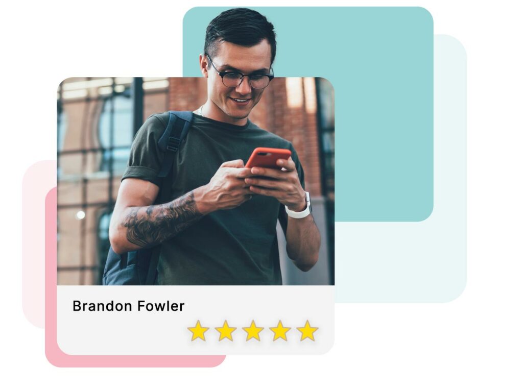 Young man smiling as he fills out a review on his cell phone