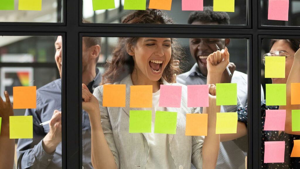 Marketing team brainstorming with post-it notes on windows