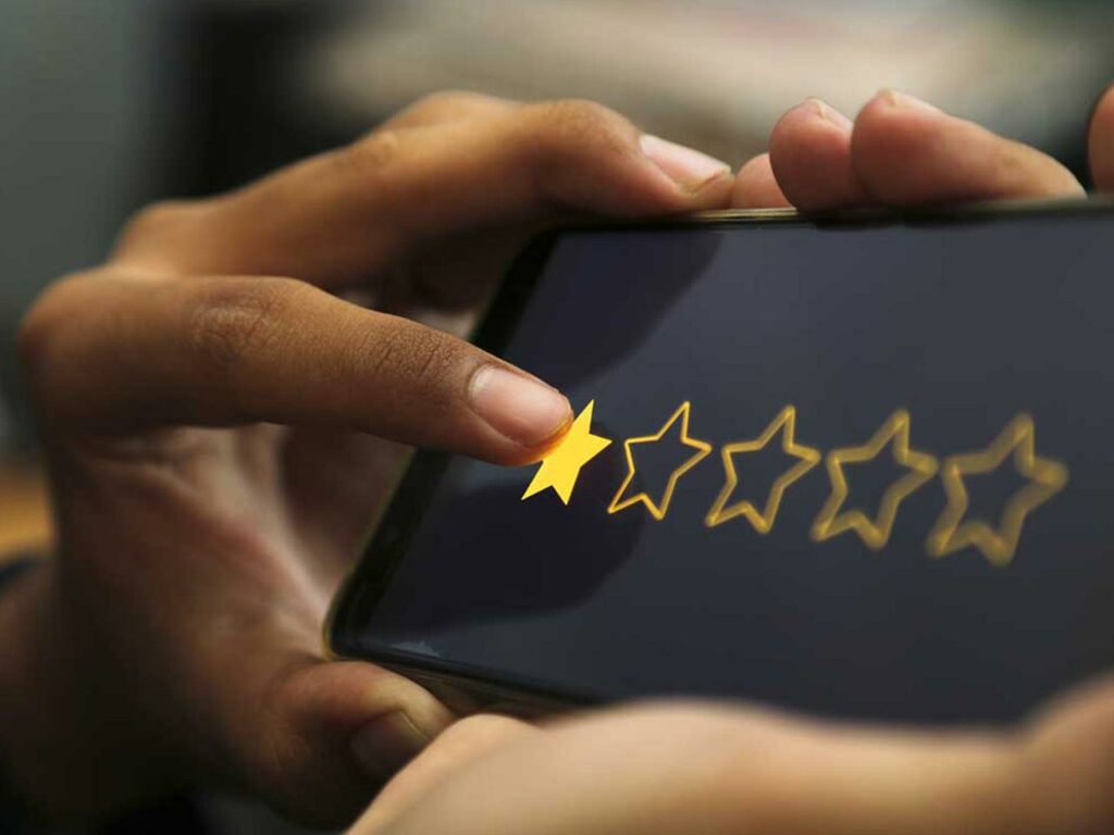 Closeup of a finger tapping a 1-star review on a tablet
