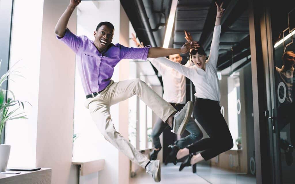 Teammates jumping for joy in an office